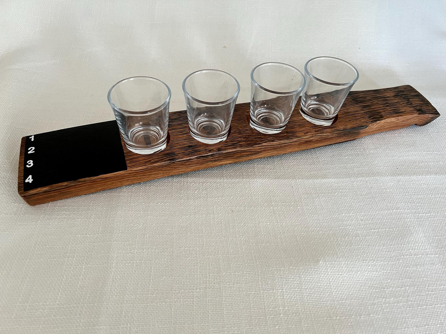 Oak wood shot flight board with four slots and a chalkboard.